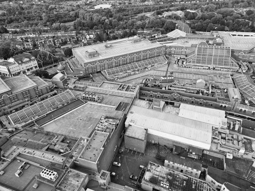 A wide view of a densely cluttered scrapyard or waste collection site with tall, uneven stacks of scrap materials, including rusted metal sheets, discarded wooden planks, and various miscellaneous deb